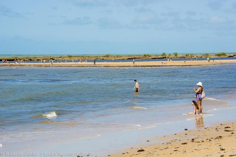 Imagem de mãe e filha tirando foto do belo mar da Praia de Santo André.